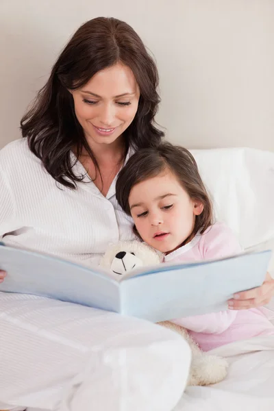 Porträtt av en mamma som läser en historia till sin dotter — Stockfoto