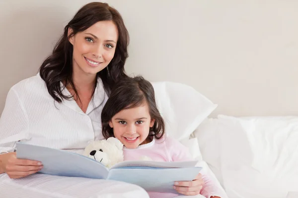 Happy mother reading a story to her daughter — Stock Photo, Image