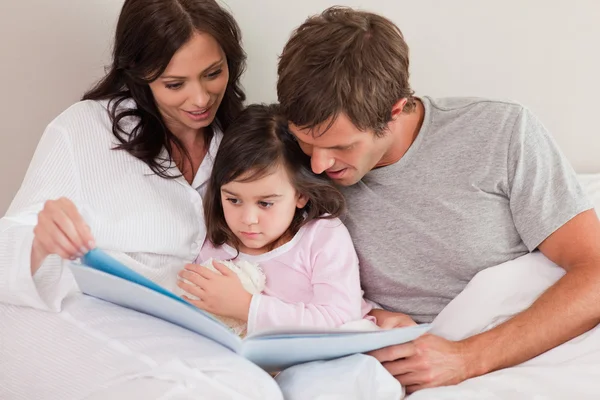 Ebeveynler kendi kızı için bir hikaye okuma — Stok fotoğraf