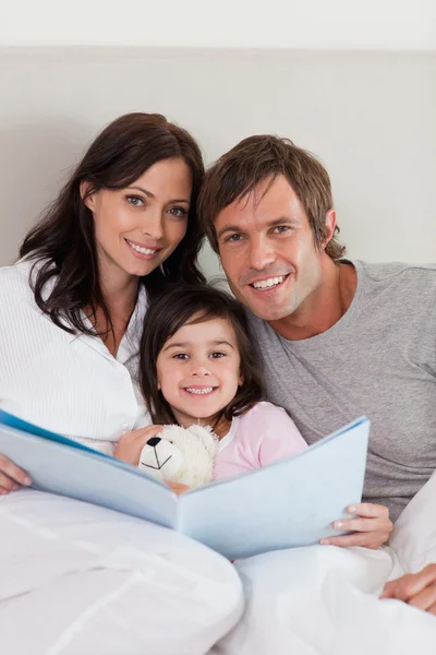 Portrait of parents reading a story to their daughter — Stock Photo, Image