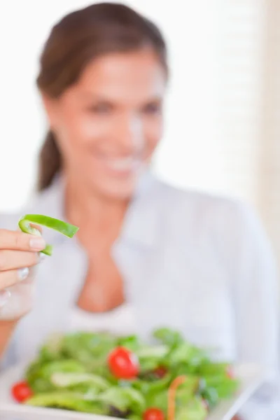 Portret van een jonge vrouw die het eten van een salade — Stockfoto
