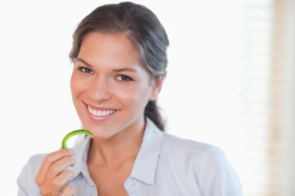 Femme souriante mangeant une tranche de poivre — Photo