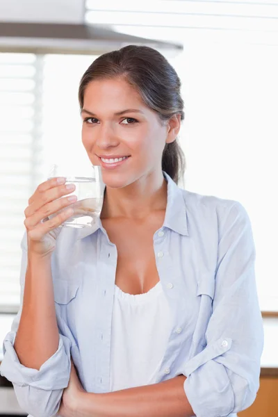 Portret kobiety uśmiechający się trzymając szklankę wody — Zdjęcie stockowe