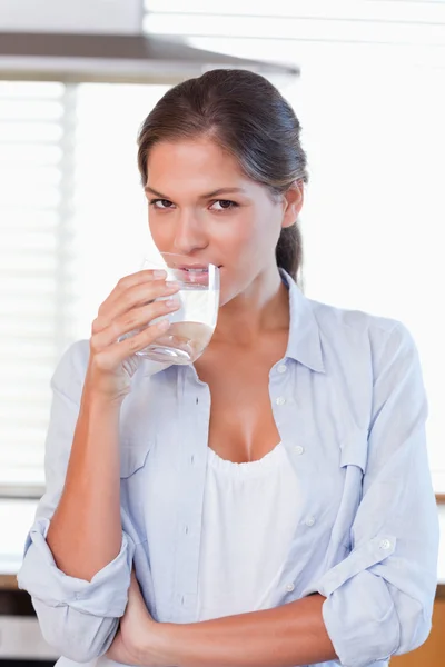 Retrato de uma jovem mulher bebendo um copo de água — Fotografia de Stock