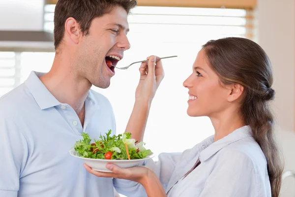 Accomplice couple tasting a salad — Stock Photo, Image