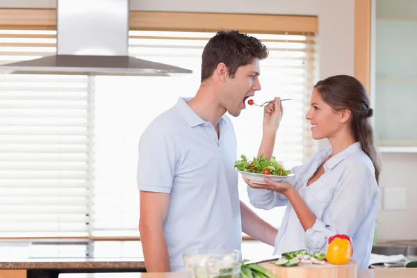 Casal feliz provando uma salada — Fotografia de Stock