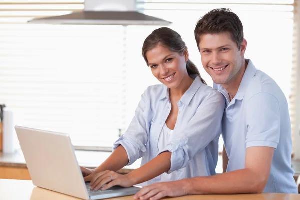 Leende par använder en bärbar dator — Stockfoto