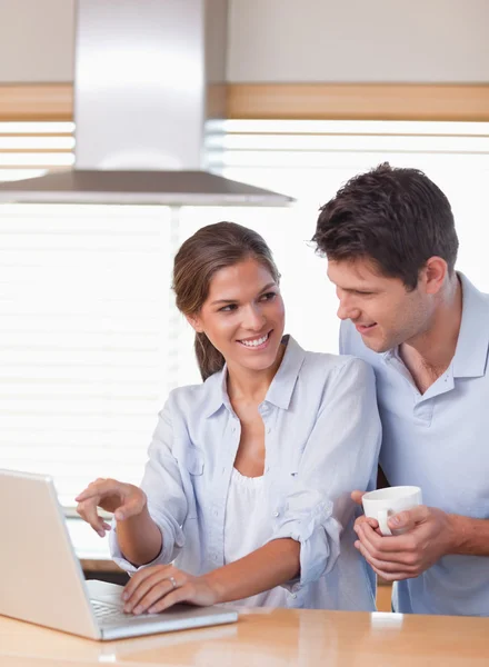 Retrato de um casal usando um laptop enquanto toma chá — Fotografia de Stock