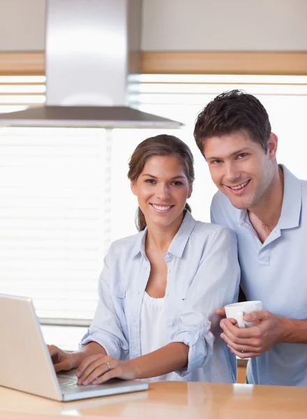 Porträt eines Paares, das beim Kaffeetrinken einen Laptop benutzt — Stockfoto
