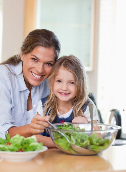 Portret van een moeder en haar dochter voorbereiding van een salade — Stockfoto