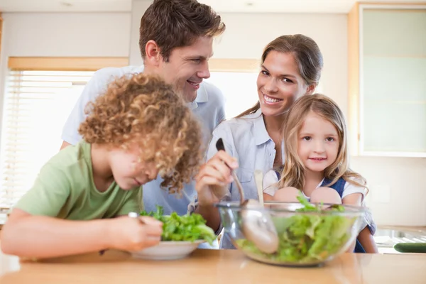 Lycklig familj förbereder en sallad — Stockfoto