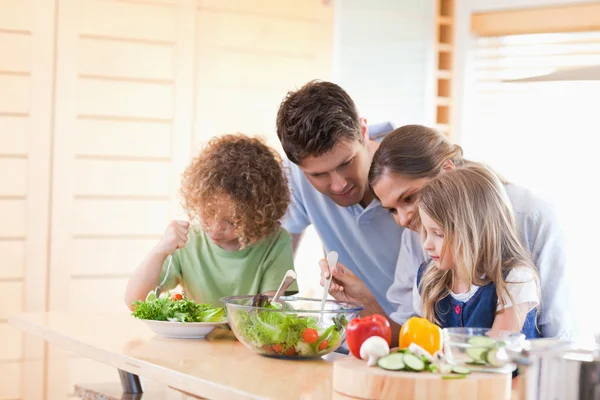 Familjen förbereder en sallad tillsammans — Stockfoto