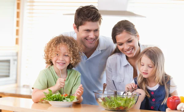 Boldog család készül a saláta össze — Stock Fotó