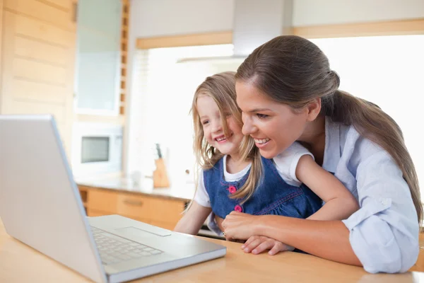 微笑的母亲和她的女儿使用一台笔记本电脑 — 图库照片