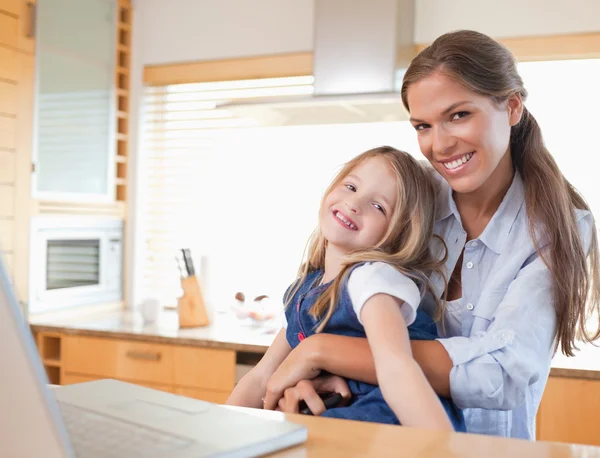 Mutlu anne ve kızı bir dizüstü bilgisayar kullanarak — Stok fotoğraf
