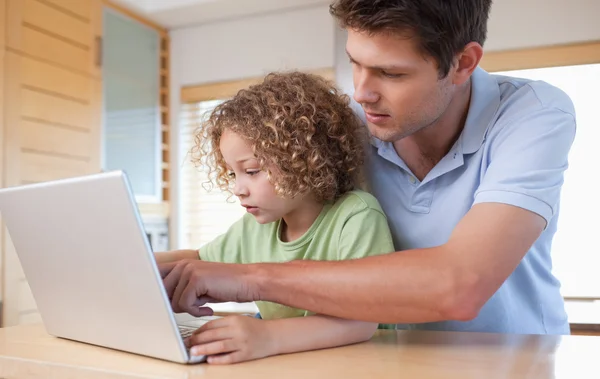 Jongen en zijn vader met behulp van een laptop — Stockfoto