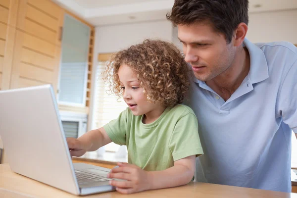 Jongen en zijn vader een laptop gebruiken — Stockfoto