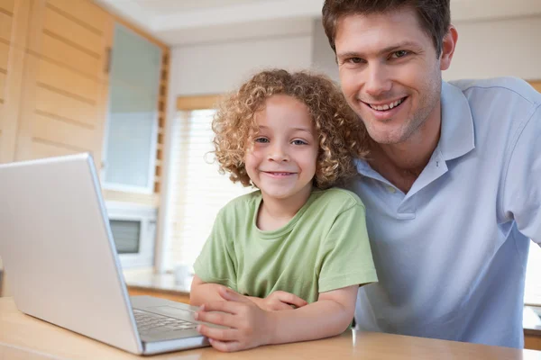 Mutlu çocuk ve babası bir dizüstü bilgisayar kullanarak — Stok fotoğraf