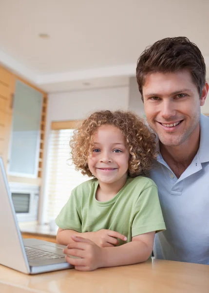Bir çocuk ve babası bir dizüstü bilgisayar kullanarak portresi — Stok fotoğraf