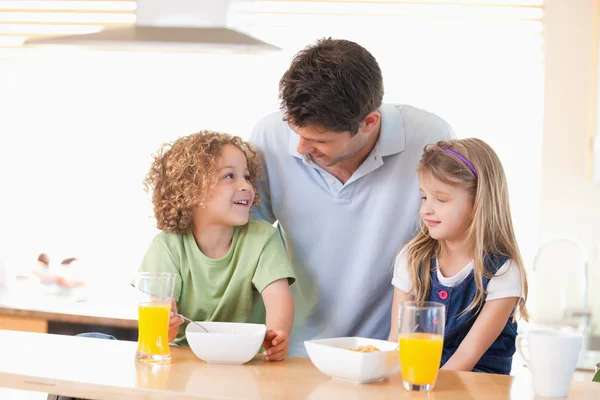 微笑的父亲与他的孩子们吃早餐 — 图库照片