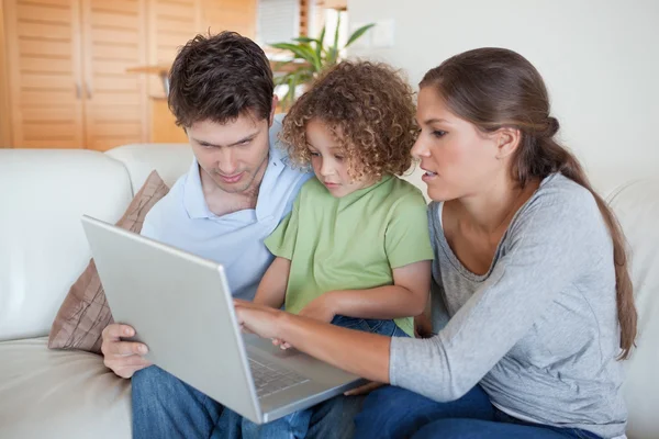 Ung familj använder en bärbar dator — Stockfoto