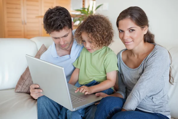Jeune famille utilisant un ordinateur portable — Photo