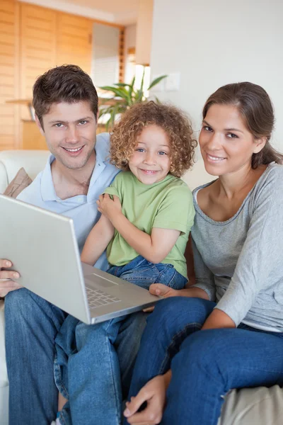 Retrato de una familia usando un portátil — Foto de Stock