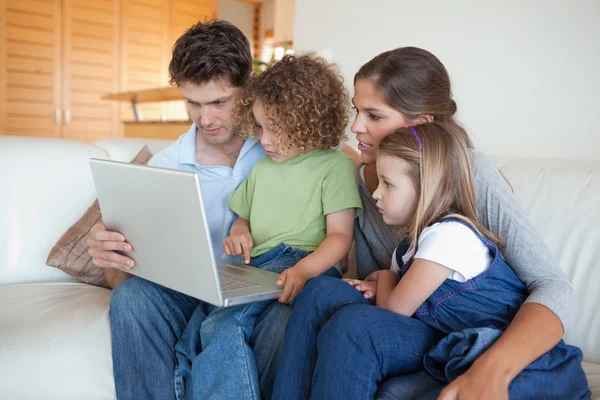 Familia enfocada usando un portátil — Foto de Stock