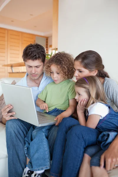 Porträtt av en familj som använder en bärbar dator — Stockfoto