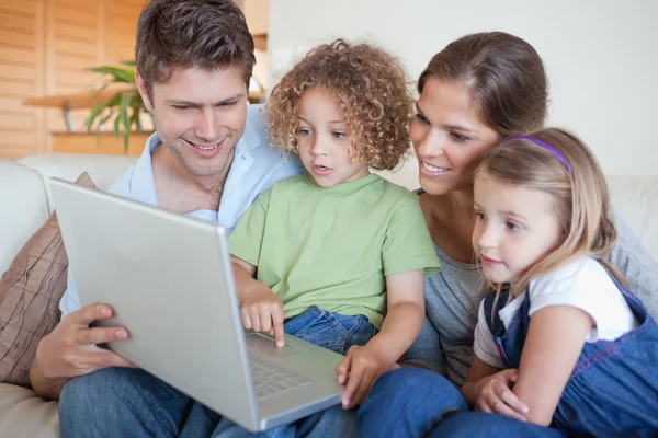 Familia serena usando un portátil — Foto de Stock