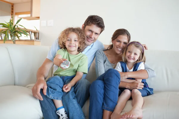 Gülümseyen aile birlikte TV izleme — Stok fotoğraf