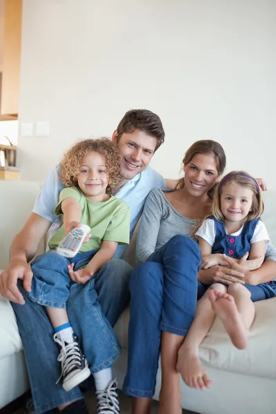 Porträtt av en lycklig familj tittar på tv tillsammans — Stockfoto