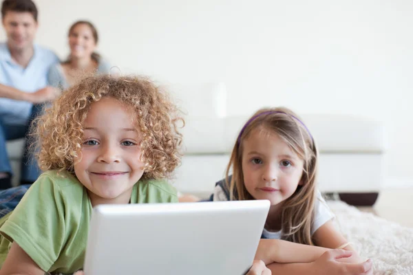 Onların mutlu paren ise tablet bilgisayar kullanan çocuk gülümseyen — Stok fotoğraf