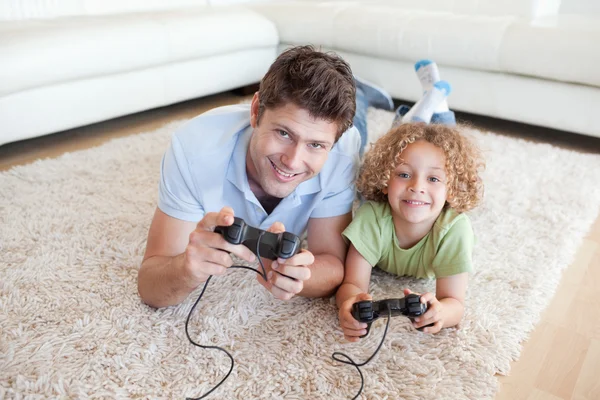 Garoto sorridente e seu pai jogando videogames — Fotografia de Stock