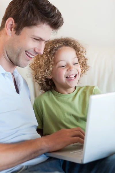 一个可爱的男孩和他的父亲使用的便携式计算机的肖像 — 图库照片