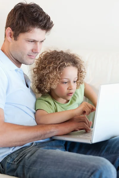 Retrato de um menino e seu pai usando um laptop — Fotografia de Stock