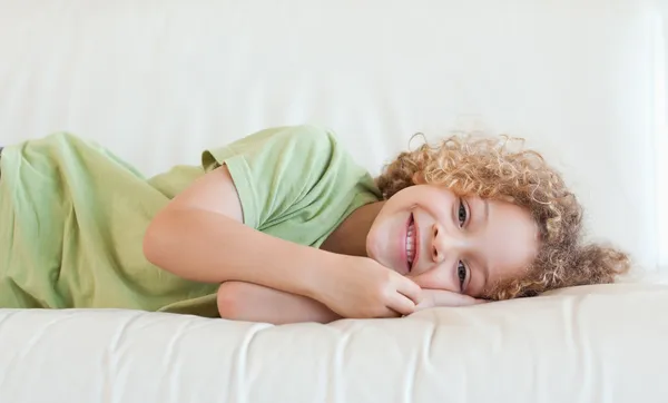 Gelukkige jongen liggen op een sofa — Stockfoto