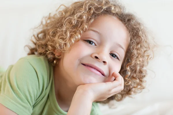 Close up of a smiling boy lying on a sofa — Stock Photo, Image
