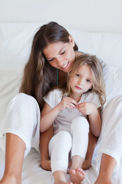 Portrait of a mother and her daughter posing on a bed — Stock Photo, Image