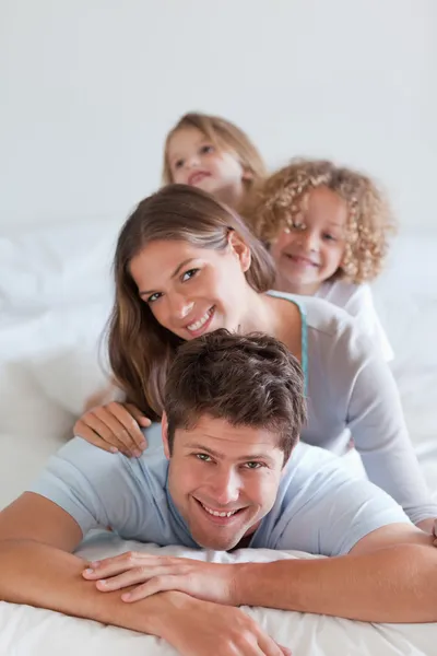 Porträt einer fröhlichen Familie, die aufeinander liegt — Stockfoto