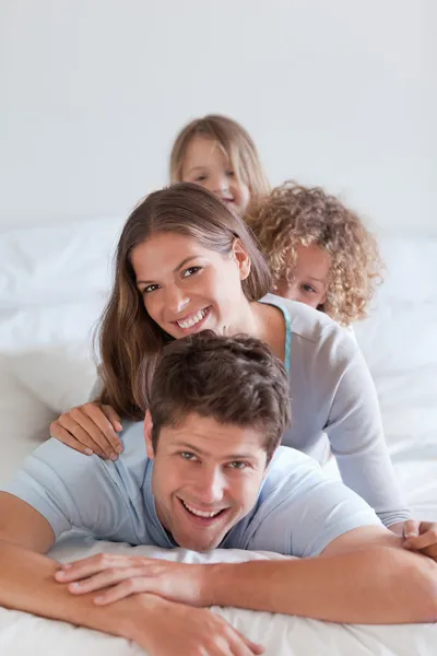 Портрет счастливой семьи, лежащей друг на друге — стоковое фото