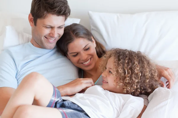 Ontspannen op een bed en gelukkige familie — Stockfoto