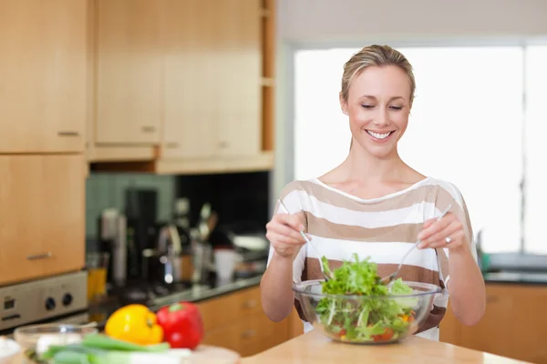 Smiling woman preparing meal — Stock Photo, Image