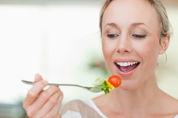 Vrouw die een tomaat eet — Stockfoto