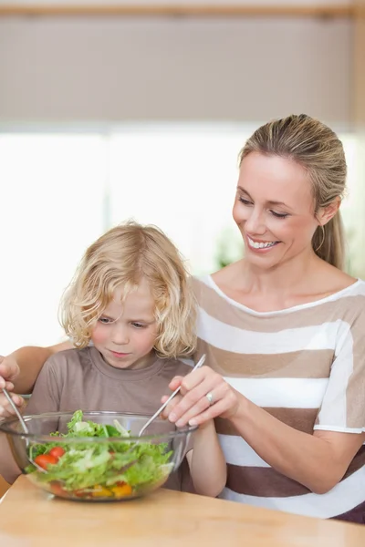 Mother and son stirring salad — Stok fotoğraf