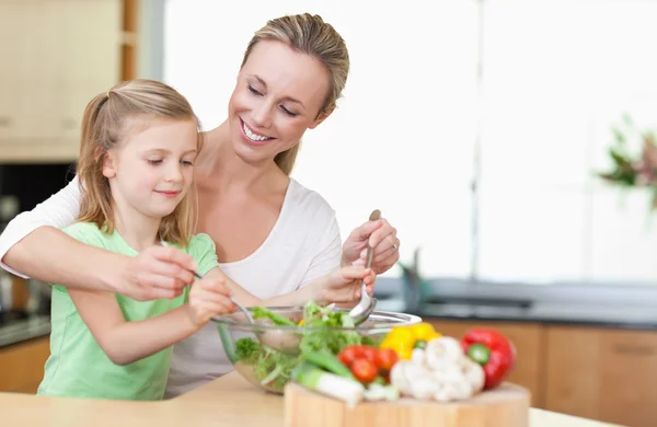 Madre e figlia mescolando insalata — Foto Stock