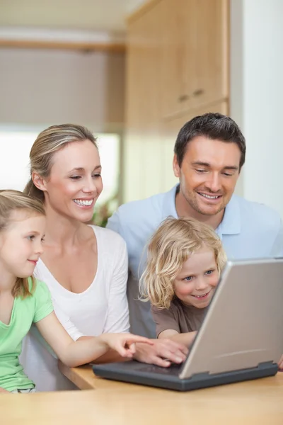 Family using laptop in the kitchen — Stock Photo, Image