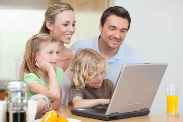 Family using the internet in the kitchen — Stock Photo, Image