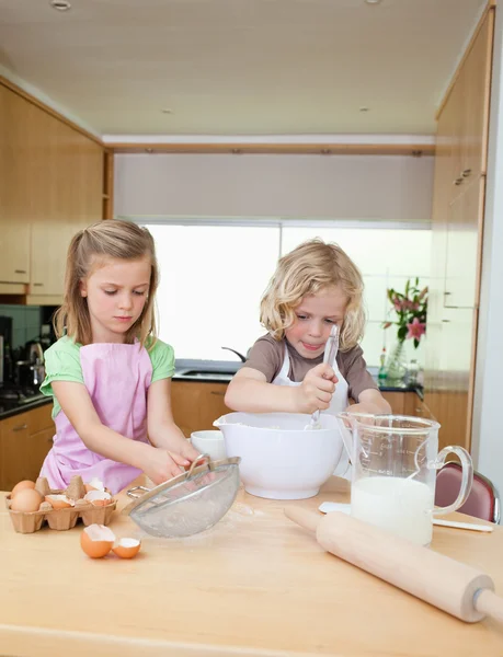 Brother and sister preparing dough — Stock Photo, Image