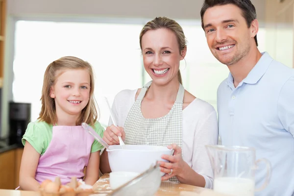 Girl preparing dough with her parents — Stock Photo, Image